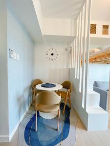 圣费尔南多GBU's Studio with Balcony at Azure North Pampanga的一间带桌椅和时钟的用餐室