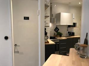 赫尔辛基Beautiful city apartment at Kallio的厨房设有一扇门,可通往带桌子的厨房