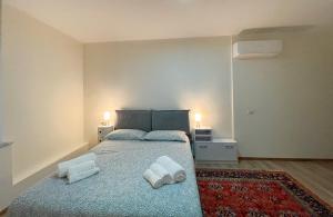 卡利亚里Extravaganza Room and Suite Apartment City Center的一间卧室配有一张床,上面有两条毛巾