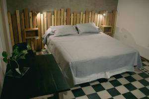 门多萨El Alero Hospedaje的卧室配有白色的床和木制床头板