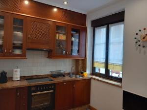 希洪MenVal16的厨房配有木制橱柜、水槽和窗户。