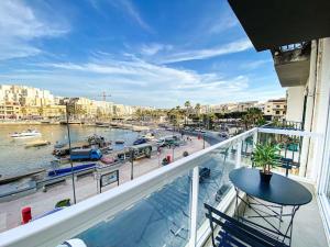 马尔萨斯卡拉Seafront 1st floor Apartment in Marsaskala by Solea的阳台享有带船只的海港景色。