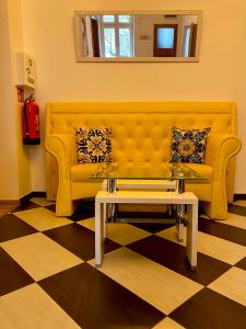 克拉科夫Topolove Rooms & Apartments的客厅配有黄色沙发及茶几