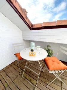昂古莱姆Centre ville, T2 tout confort lumineux et calme !的庭院里配有一张白色的桌子和两把椅子
