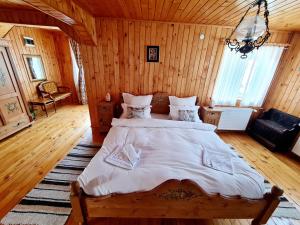 普雷代亚尔Casa RAI的木制客房内的一间卧室配有一张大床