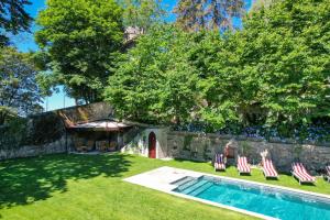 布鲁纳特Relais Villino Rubini的一个带躺椅的庭院和一个游泳池