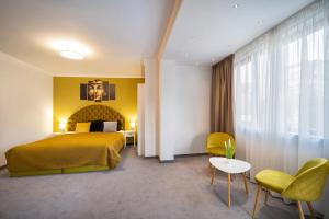 多布里奇Hotel Rivera的酒店客房带一张床、一张桌子和椅子