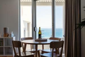 珀斯Cottesloe Beach View Apartments #11的用餐室配有带1瓶葡萄酒的桌子