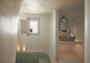 易莫洛林Atoles Retreat的带浴缸的浴室和窗户。