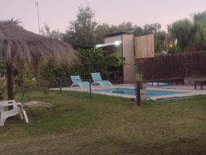 圣拉斐尔Cabañas Bella Alba的一座房子旁的游泳池,配有蓝色的椅子