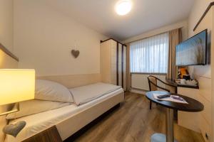 Struckum斯托克姆森林酒店的客房设有1张床、1张桌子和1台电视。