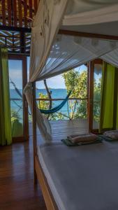BombaAraya Dive Resort Togean的一间卧室设有一张床,享有海景