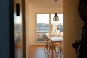 威斯巴登Penthouse I Dachterrasse I Tiefgaragenstellplatz I nahe Bhf, JoHo, Brita-Arena的客房设有桌椅和窗户。