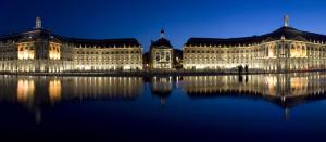 波尔多Magnifique Appartement avec climatisation en Hyper Centre de Bordeaux的一座在夜间水面上灯亮的大建筑