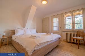 阿罗萨Chalet Pradella by Arosa Holiday的一间卧室配有一张带白色床单的床和一扇窗户。