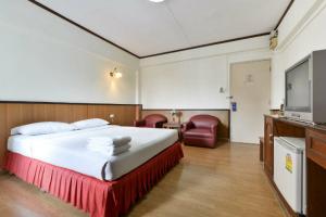 曼谷尼斯皇宫酒店的配有一张床和一台平面电视的酒店客房