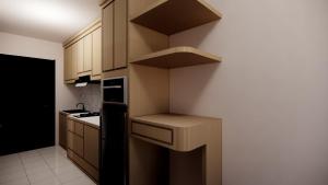 KangboiLenggo - Apartement Meisterstadt Pollux Habibie 52-05的一间设有棕色橱柜和黑冰箱的小厨房