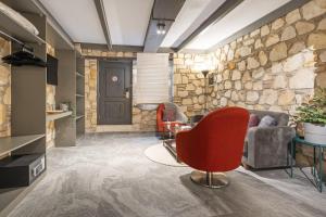 安塔利亚Charming Flat near Hadrians Gate的客厅设有石墙和红色椅子