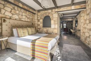 安塔利亚Charming Flat near Hadrians Gate的一间卧室设有一张床和石墙