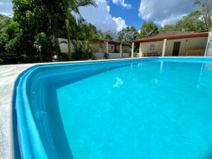 迈里波朗Chácara das Suculentas的一座大蓝色游泳池,位于房子前