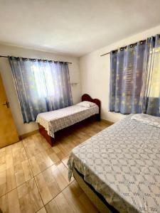 迈里波朗Chácara das Suculentas的一间卧室设有两张床和蓝色窗帘