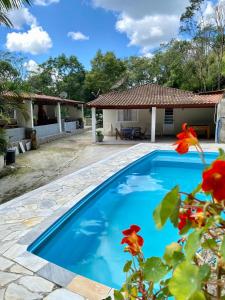 迈里波朗Chácara das Suculentas的房子前面的蓝色游泳池