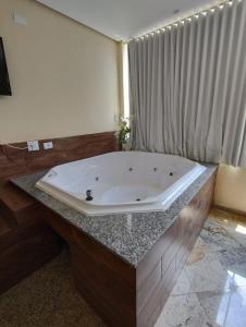 波苏斯-迪卡尔达斯Hotel Pousada Beija Flor的浴室内一个位于柜台上的大型浴缸