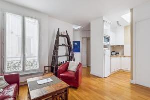 巴黎Charming Parisian Apartment的一间带梯子和红色椅子的客厅