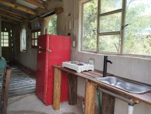 坦季ECO-LOFT, Sombra de Chañar,- Mallín Córdoba的厨房配有水槽和红色冰箱