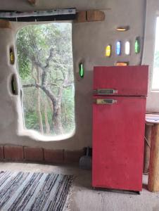 坦季ECO-LOFT, Sombra de Chañar,- Mallín Córdoba的窗户客房内的红色冰箱