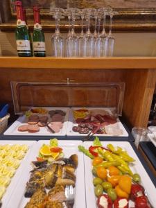 奥斯特西巴德钦诺维茨豪斯苏布雷可酒店伽尔尼&菲利恩吾航根的自助餐,包括几盘食物和瓶装葡萄酒