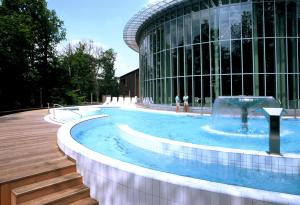 斯帕Luxury Spa Hotel - Automobile的一座大楼前的游泳池,带喷泉
