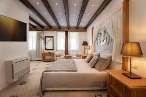 普拉Villa Cavalieri Country Hotel的一间卧室配有一张大床和电视