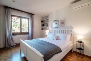 戈尔多拉Lilia Apartment by Quokka 360 - large flat with panoramic view of Locarno的白色的卧室设有一张大床和一个窗户