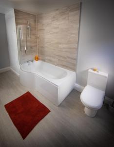 凯西克Loft Apartment, Keswick的浴室配有白色浴缸和卫生间。