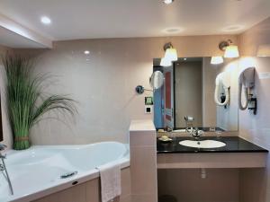 瑟堡Logis HOTEL RESTAURANT La Régence的带浴缸和盥洗盆的浴室