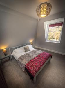 凯西克Loft Apartment, Keswick的一间卧室配有一张带红色毯子的床和窗户。