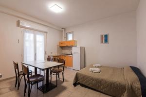 里乔内Residence Das Nest的一间带桌子和床的卧室以及一间厨房