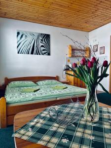 特尔乔夫Penzion pod Brehom的一间卧室配有一张床和一张花瓶桌子