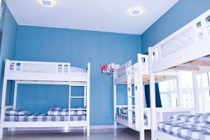 迪拜Hawana Hostel的蓝色墙壁的客房内设有两张双层床。