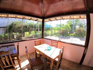 戈亚斯州上帕莱索Pousada Casa Rosa的窗户间里的桌椅