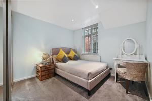 伦敦Hampstead Opulence Apartment - Luxurious Split Level Property的一间卧室配有一张床、一张书桌和一面镜子