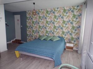 Méry-sur-CherA la Belle Etoile的一间卧室配有一张蓝色的床和热带壁纸