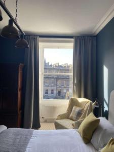 爱丁堡West End Townhouse的卧室配有床、椅子和窗户。