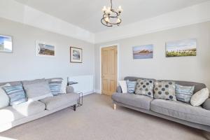 科布里奇Host & Stay - The Cottage in Corbridge的客厅配有两张沙发和一个吊灯。