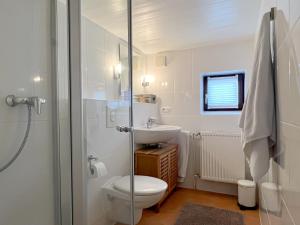 塔廷格Reetkate Reetdachhaus Friesen Chalet的白色的浴室设有卫生间和水槽。