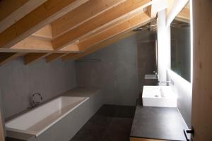 GsteigChalet mit Kino und Jacuzzi in Gsteig b. Gstaad的浴室配有白色浴缸和水槽