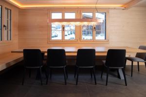GsteigChalet mit Kino und Jacuzzi in Gsteig b. Gstaad的用餐室配有大型木桌和椅子