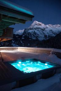 GsteigChalet mit Kino und Jacuzzi in Gsteig b. Gstaad的雪中与山间的热水浴池