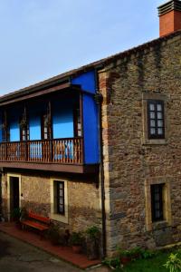 CarrenoCasa Rural Casa Selmo的带阳台和长凳的砖砌建筑